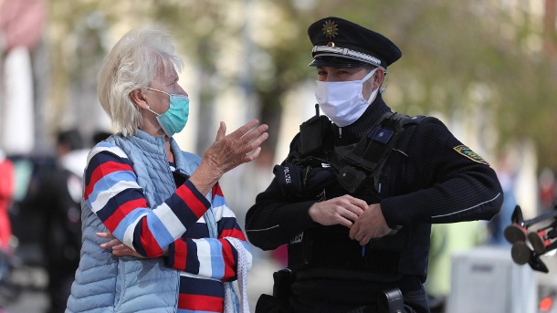 Eine Seniorin und ein Polizist mit Mund-Nasen-Schutz: Der Bund hat das Tragen von Masken dringend empfohlen – in immer mehr Bundesländern gibt es jetzt auch eine Pflicht. (Symbolbild) (Quelle: imago images)