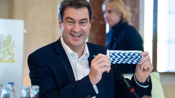Markus Söder während der Kabinettssitzung: Der Ministerpräsident von Bayern zeigt eine Gesichtsmaske mit der bayerische Rautenflagge. (Quelle: dpa/Sven Hoppe)