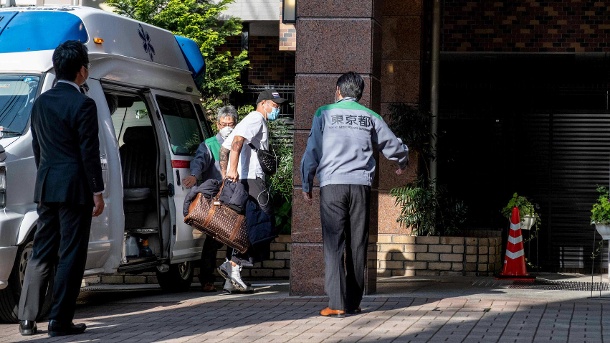 Ein Corona-Patient verlässt einen Krankenwagen: In Japan werden Hotels derzeit als Unterkunft für Patienten mit milden Symptomen genutzt, um Krankenhausbetten freizuhalten. (Quelle: imago images/Viola Kam)
