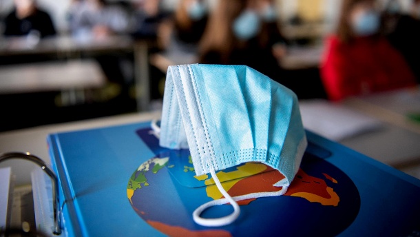 Eine Schutzmaske liegt in einer Schulklasse: Das Robert-Koch-Institut hat am Donnerstag wieder mehr als 10.000 Corona-Neuinfektionen gemeldet. (Quelle: dpa)